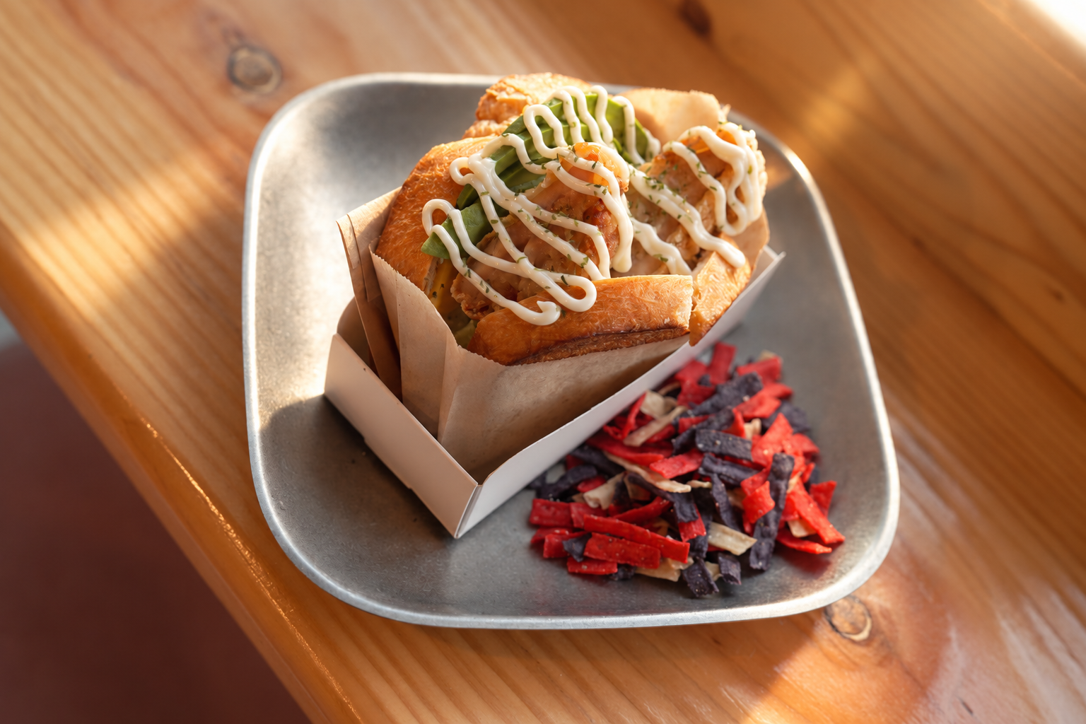 Chicken sandwich with avocado on a plate at Coffee Nutz